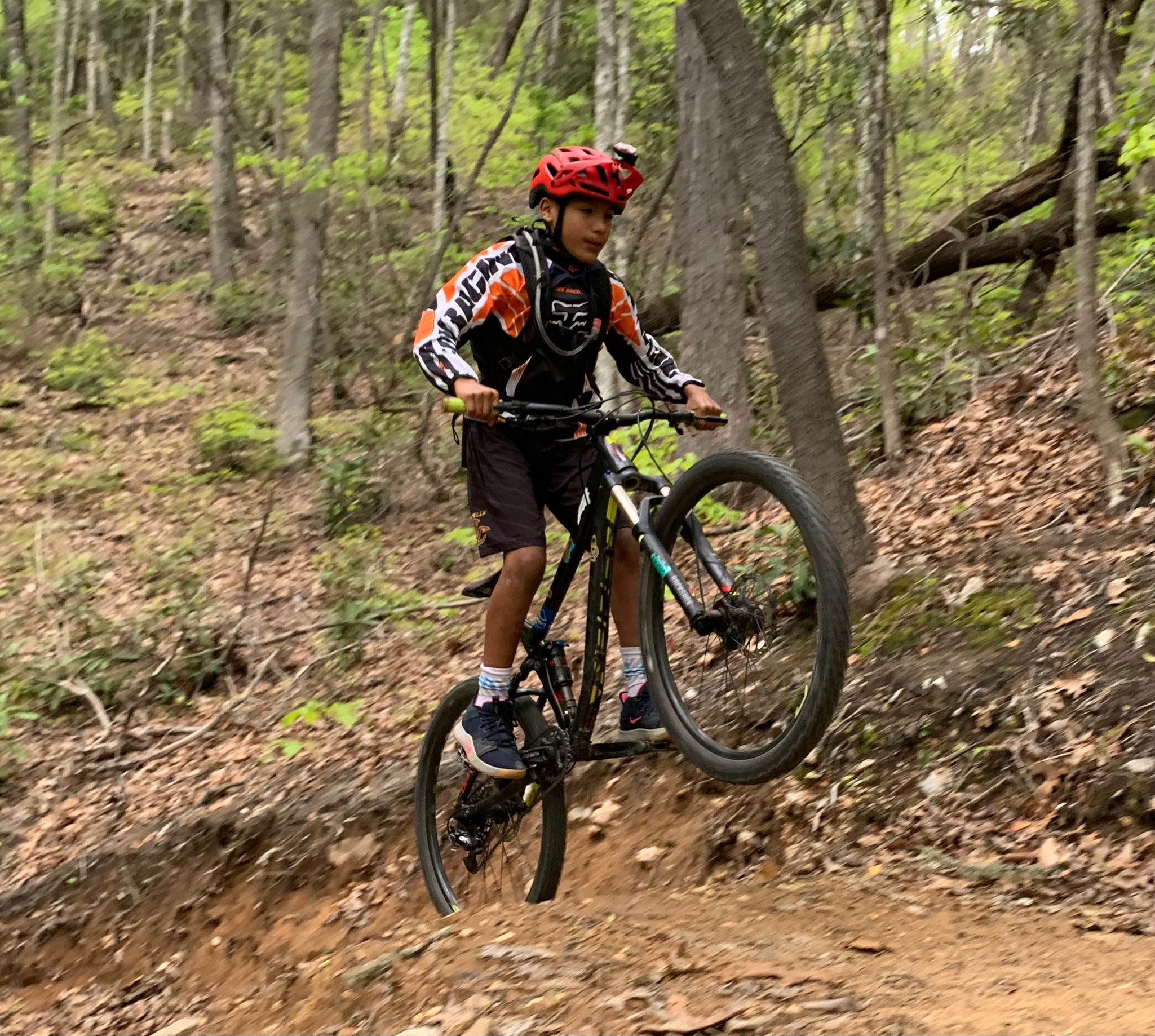 A man riding a bike on top of a dirt trail.